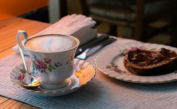 A cup of coffee and toast, evoking Italy’s caffè sospeso tradition of buying coffee for strangers.